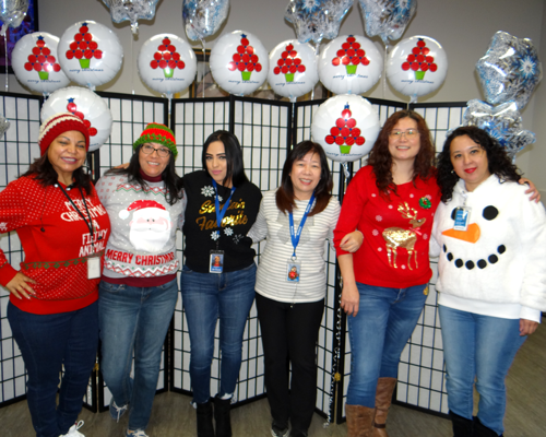 CyraCom Phoenix Center employees in holiday sweaters