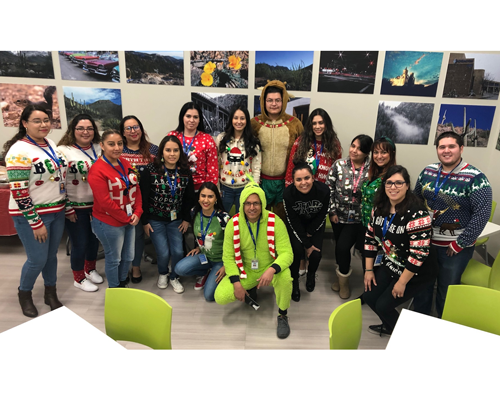 CyraCom Employees pose for group picture in holiday sweaters