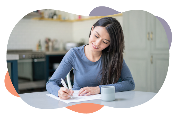 woman writes notes in her kitchen