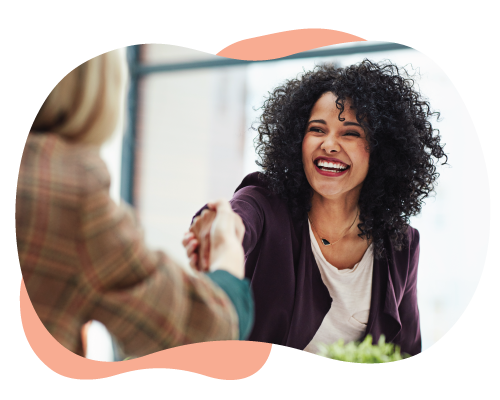 women shaking hands and smiling