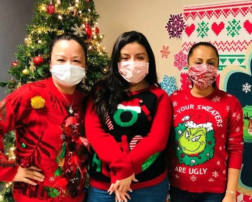 CyraCom Houston Center employees pose by holiday decorations