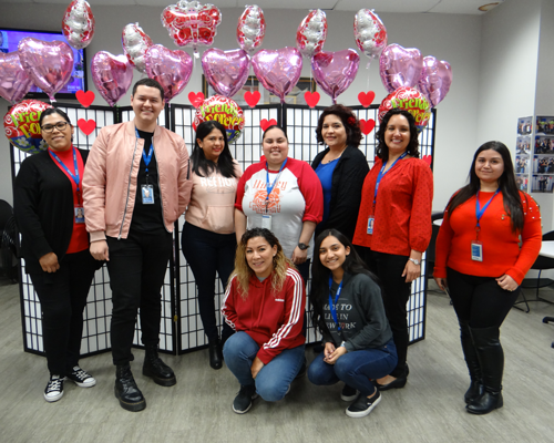 CyraCom Phoenix Center employees posing by Valentine decorations